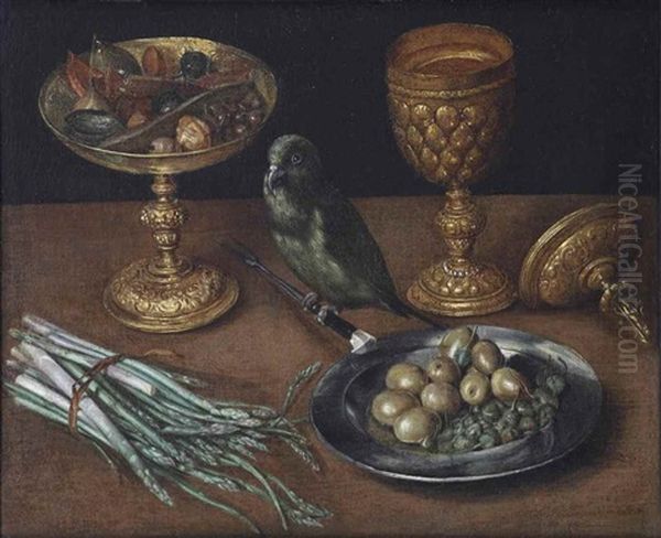 A Golden Tazza With Dates And Dried Fruits, A Golden Goblet And Cover, A Tin Plate With Olives And Capers And A Green Finch Seated On A Fork, Together With Asparagus On A Wooden Table Oil Painting by Georg Flegel